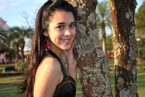 photo of a girl near a tree trunk