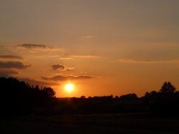 the sun at sunset on a background of clouds