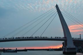 people on the bridge at sunset