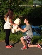 guy gives the girl a teddy bear drawing