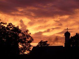 romantic sunset on the background of trees and roofs of houses