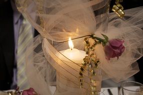candle in wail with pink rose, table decoration