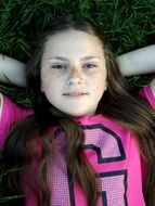 girl with freckles lying on the grass