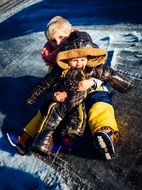 two caucasian child boys playing on snow ourdoor