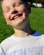 happy boy on green grass background