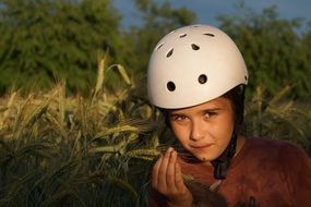 child in helmet on a grain field