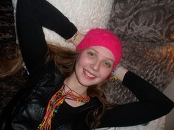 Smiling girl in bright crimson hat and bright beads
