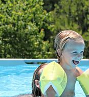 Happy smiling girl in the swimming pool