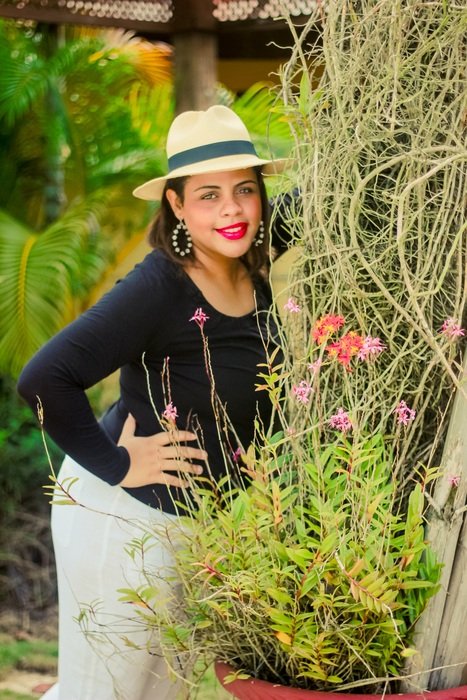 woman in a hat against the backdrop of greenery