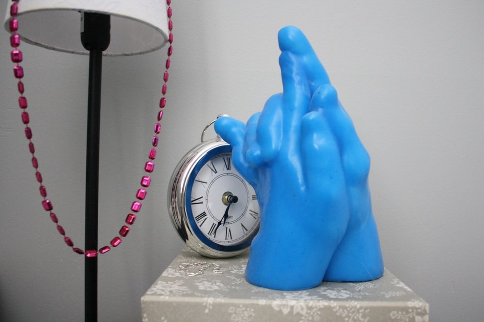 blue figure of entwined hands on the bedside table