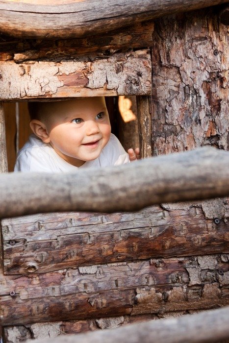 Happy baby in a wooden house