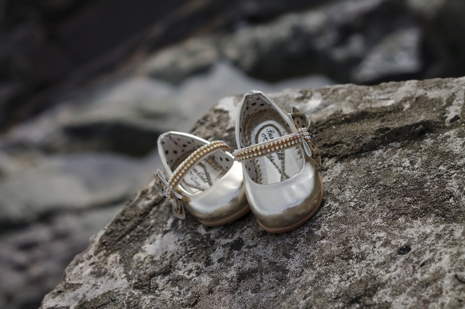 pair of children’s slippers on grey stone