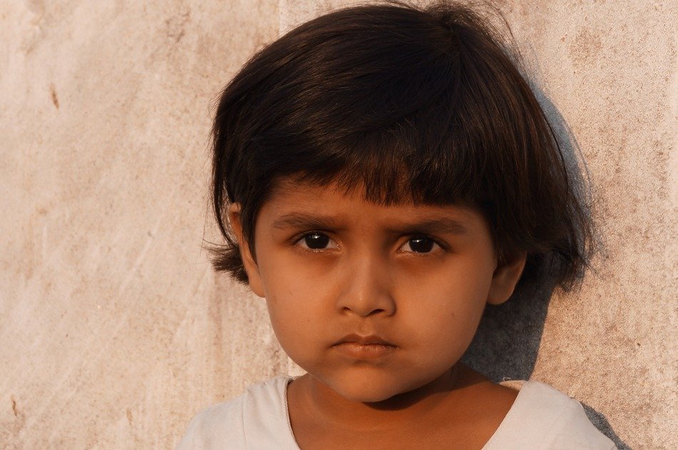 sad little child near the wall