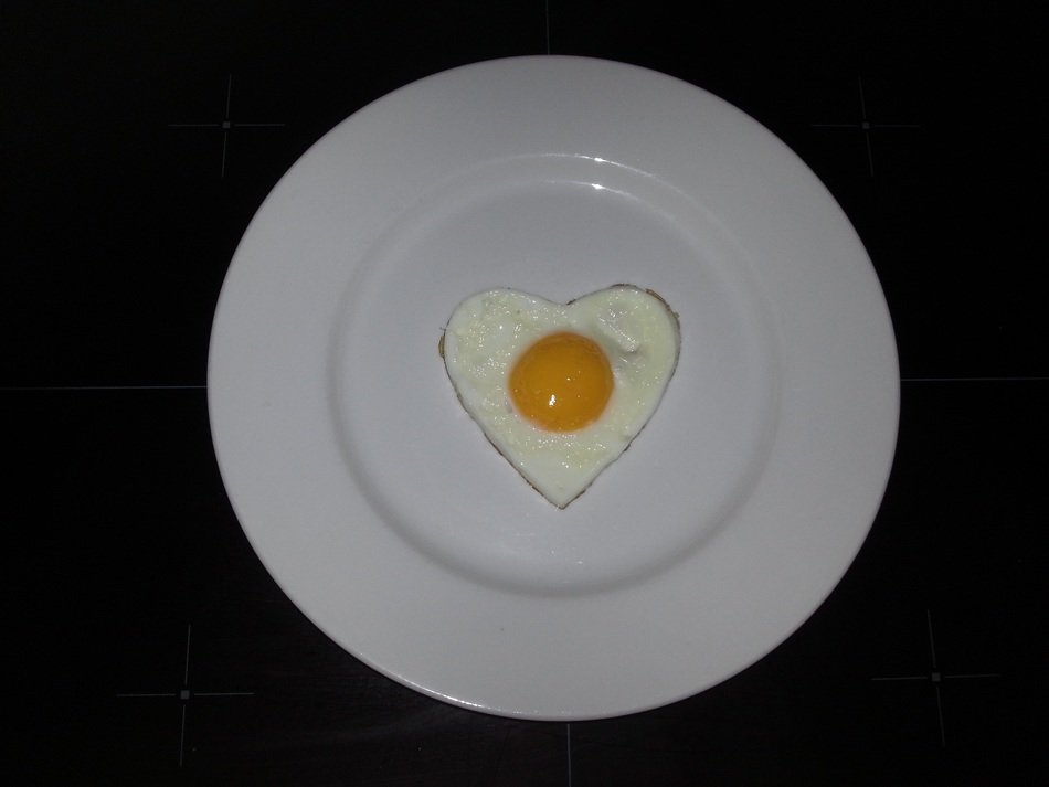 fried eggs in the shape of a heart on a plate