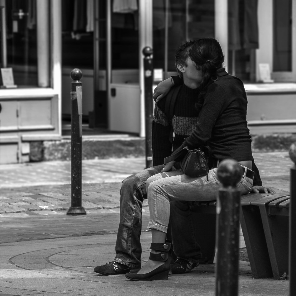 kissing couple on bench in town