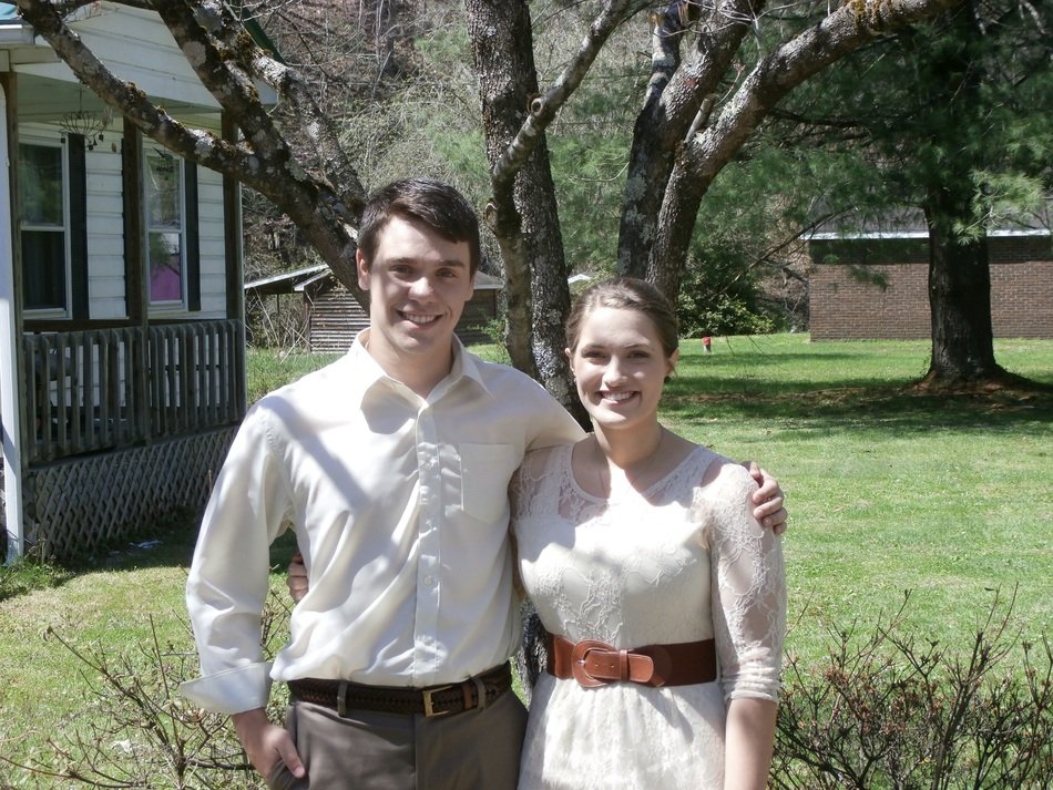 smiling young caucasian couple at garden before country house