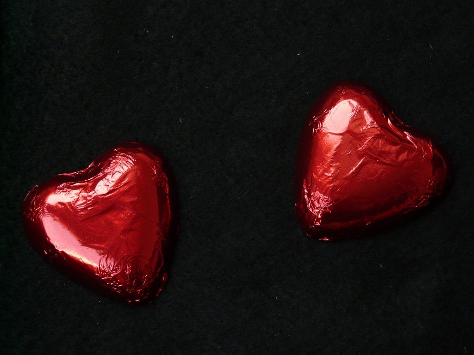 packed red hearts chocolate on a black background