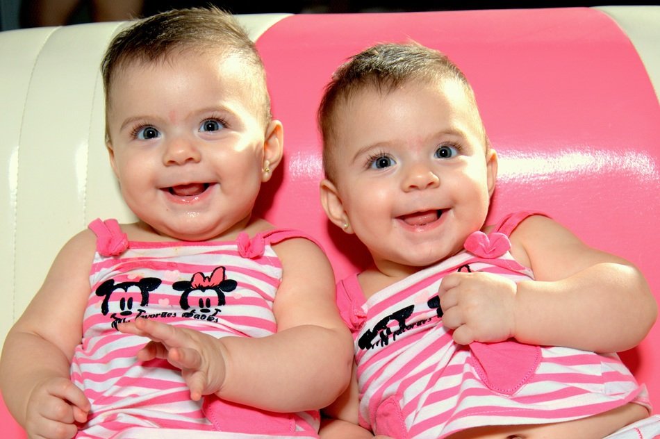 twins in striped clothes are smiling