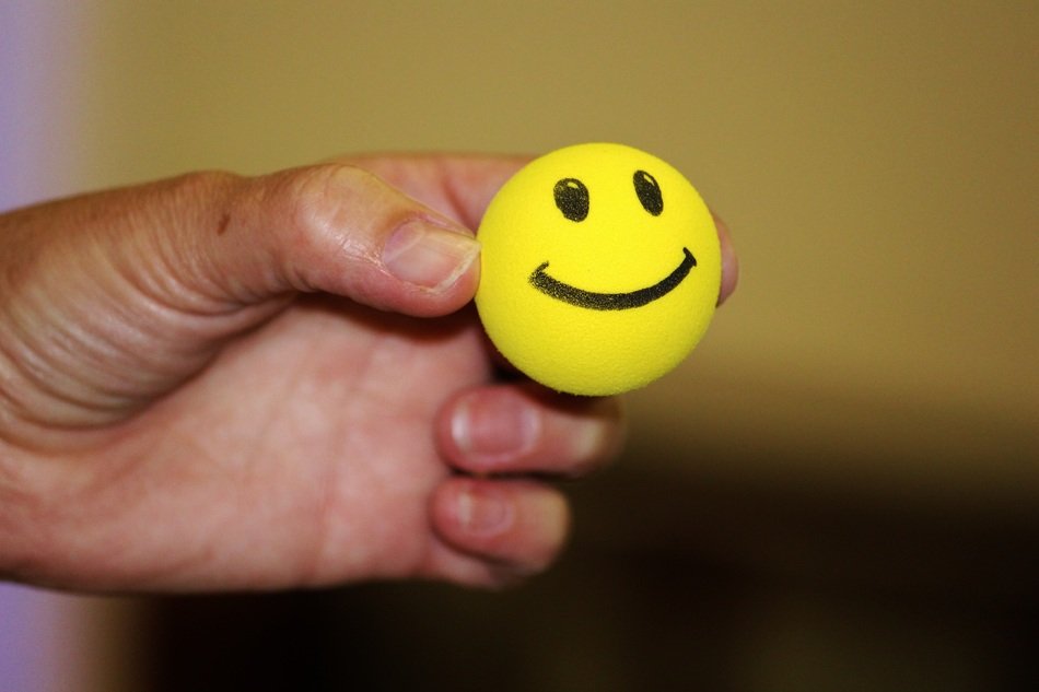 ball in the form of a smiley in the hand of man