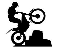silhouette of a man on a motorcycle during a stunt