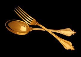 golden spoon and fork on a black background