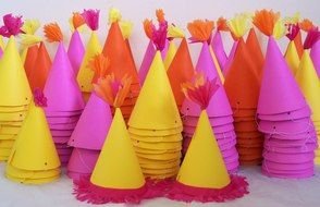 lot of Pink And Orange Party hats in stacks