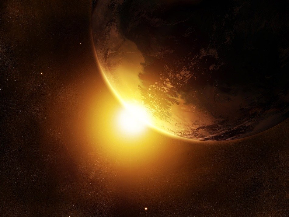 the golden sun peeks out from behind the planet Earth