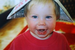 cheerful child in the newspaper cap