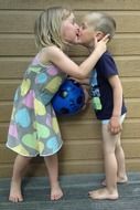 kiss of a boy and a girl on the background of the wall