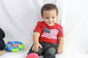 the baby in a red T-shirt with the flag of the USA