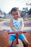 smiling boy on a swing in the park