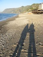 Human shadows on a sand beach