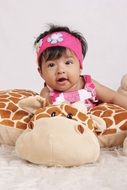 asian baby girl on toy giraffe