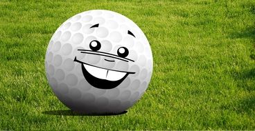 Golf ball with a face with big white teeth