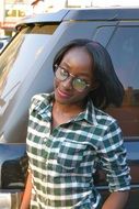 cool dark skin girl in eyeglasses at car