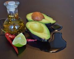 avocado with olive oil, red pepers and a piece of lime