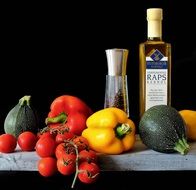 tomatoes, red pepper, yellow pepper, zucchini and a bottle of olive oil