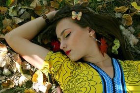 the autumn image of girl lying in colorful clothing with closed eyes
