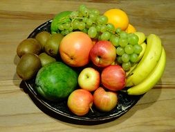 black bowl of different yummy fruits