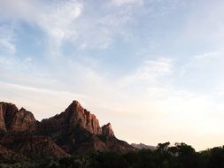 landscape of a deserted cliff with a little trees on a sunset