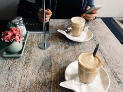 two cups of coffee on a table in a cafe