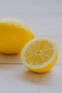 two pieces of fresh and sour lemon on a wooden table