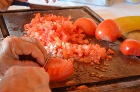 man thoroughly chopping tomatoes