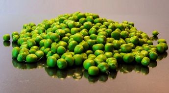 peeled green peas on glossy surface