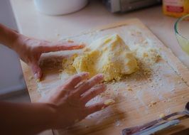 chef making dough on wooden board