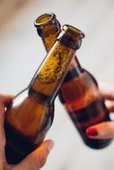 two beer bottles clinking after a toast