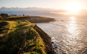 view of the ocean and hills and a golden sunset