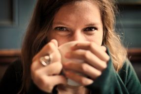 girl smiling and drinking a cup of tea