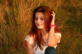 red-haired girl sitting on grass