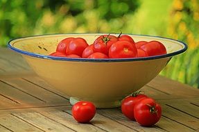 red ripe tomatoes on wooden table outdoor